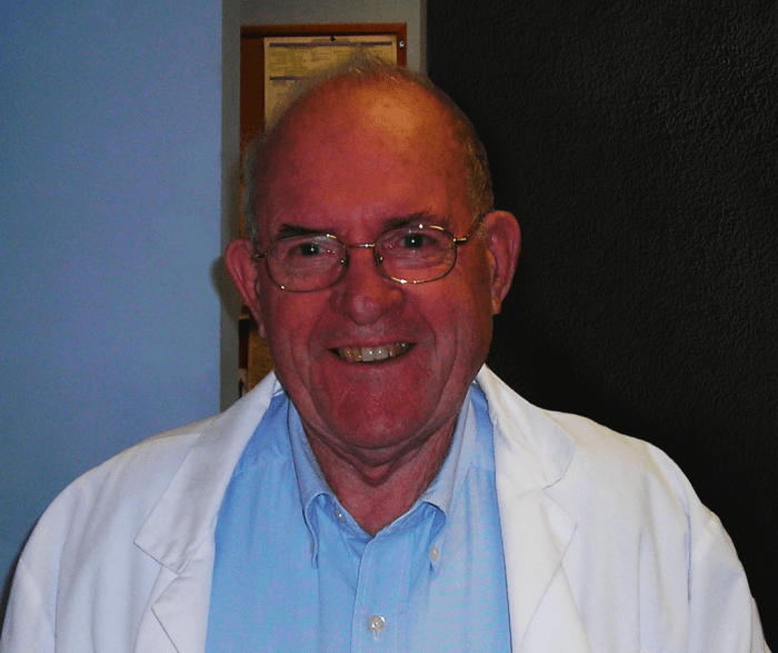male doctor smiling wearing white coat