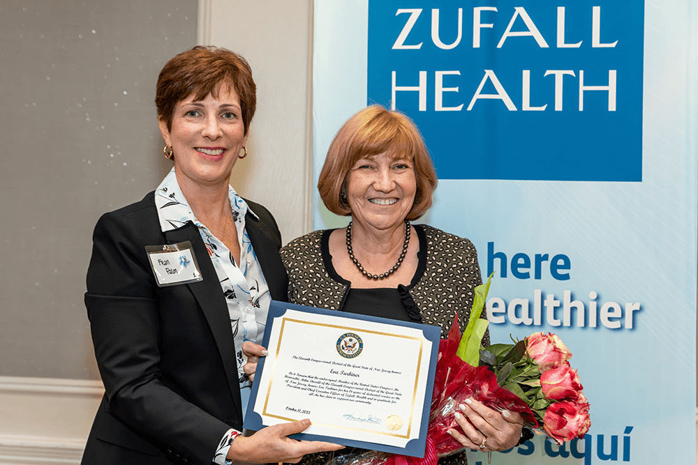 Two people holding a commemorative certificate